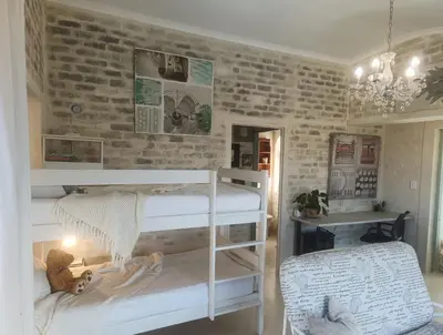 a bedroom with two bunk beds and a brick wall at KLIPWERF Bettys Bay in Bettyʼs Bay