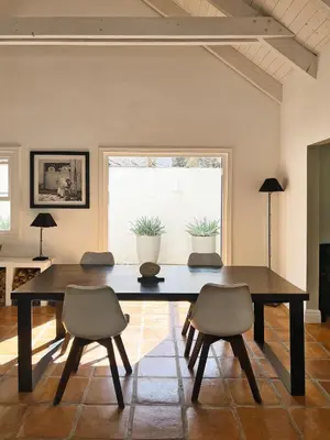 a dining room with a table and two chairs at Kumbuk House in Franschhoek