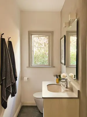 a bathroom with a sink and a toilet and a window at Kumbuk House in Franschhoek