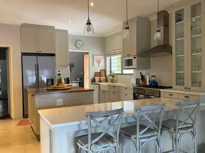 a kitchen with a large island with two bar stools at 33 Tafelberg! in Cape Town