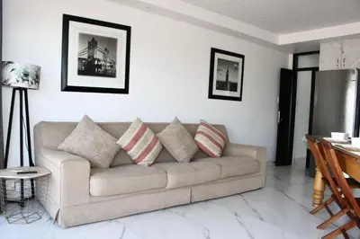 a living room with a couch with pillows on it at Sea and Mountain View Apartment in Cape Town