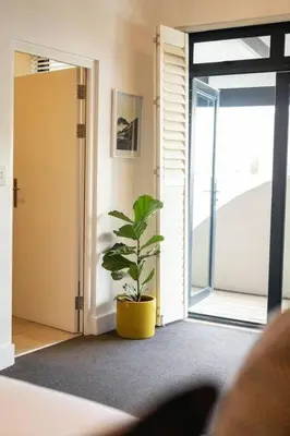a plant in a pot in a room with a door at Studio 7 - Hermanus Waterfront Apartments in Hermanus