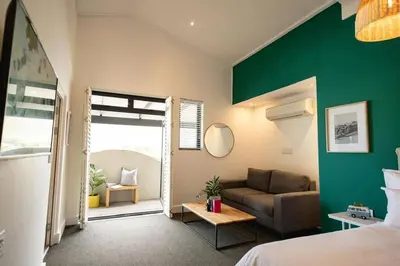a bedroom with a bed and a green wall at Studio 7 - Hermanus Waterfront Apartments in Hermanus