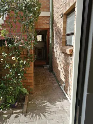 a brick alley with a door and a plant at Voëlklip Garden Flat in Hermanus