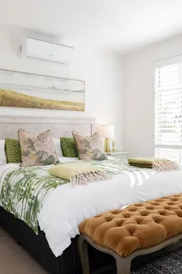 a white bedroom with a large bed with a tufted headboard at Waddle Inn Luxury apartment in Franschhoek in Franschhoek