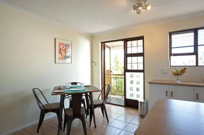 a kitchen and dining room with a table and chairs at Luxury Studio sleeps up to 3 adults - Sunset Beach in Cape Town