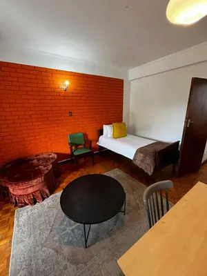 a room with a bed and a table and a brick wall at Retro City Center Gem by ARPA Hospitalities in Stellenbosch
