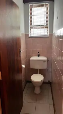 a small bathroom with a toilet and a window at Retro City Center Gem by ARPA Hospitalities in Stellenbosch