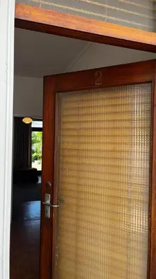an open door with a window with a curtain at Retro City Center Gem by ARPA Hospitalities in Stellenbosch