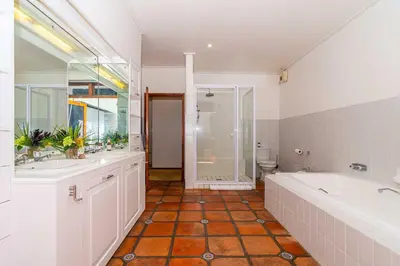 a bathroom with two sinks and a tub and a toilet at Fynbos House in Hermanus