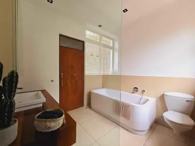 a bathroom with a white tub and a toilet at Die Regte Rede in Cape Town