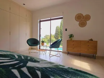 a bedroom with two chairs and a dresser and a bed at Die Regte Rede in Cape Town
