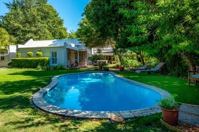 a swimming pool in the yard of a house at Beautiful country house set in lush garden in Wellington