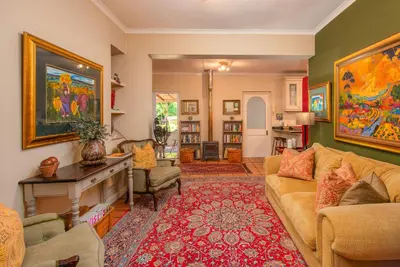 a living room with a couch and a table at Beautiful country house set in lush garden in Wellington
