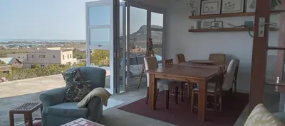 a living room with a dining room table and chairs at Red Disa in Malkopvlei
