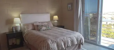 a bedroom with a bed and a large window at Red Disa in Malkopvlei