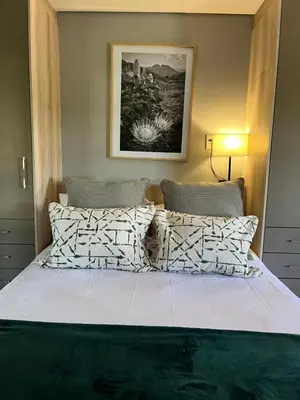 a bedroom with a large bed with two pillows at Luxury at The Den in Stellenbosch