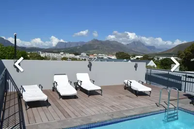 a deck with lounge chairs and a swimming pool at Luxury at The Den in Stellenbosch