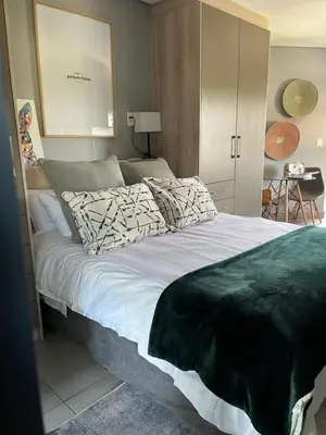a bedroom with a large bed with white sheets at Luxury at The Den in Stellenbosch
