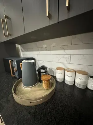 a counter top with a coffee maker and four cups at Somerset-West PRIME SPOT- Solar Powered! in Cape Town