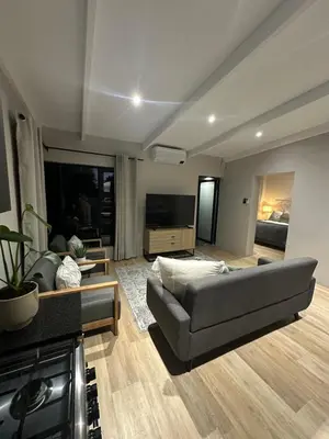 a living room with a couch and a television at Somerset-West PRIME SPOT- Solar Powered! in Cape Town