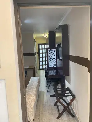 a room with a tv and a chair in a room at Delash Pine Villa in Cape Town