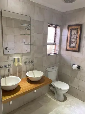 a bathroom with a sink and a toilet at Delash Pine Villa in Cape Town
