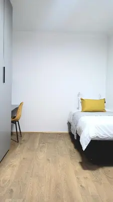 a bedroom with a bed with a yellow pillow on it at Aeon Nest in Parow