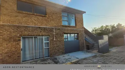 a brick house with a garage and a staircase at Aeon Nest in Parow