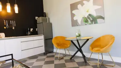 a kitchen with a table and two chairs and a refrigerator at Big6 Guesthouse in Somerset West