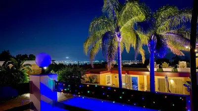 a view of a building with palm trees at night at Big6 Guesthouse in Somerset West