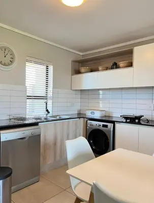 a kitchen with a sink and a dishwasher in it at Stylish waters edge apartment in Cape Town