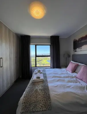 a bedroom with a bed with two towels on it at Stylish waters edge apartment in Cape Town