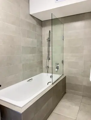 a bathroom with a tub and a glass shower at Stylish waters edge apartment in Cape Town