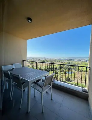 a table and chairs on a balcony with a view at Stylish waters edge apartment in Cape Town