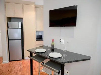 a kitchen with a table with two wine glasses and a refrigerator at Royal Boland in Paarl