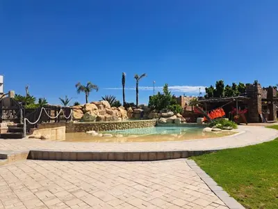 a swimming pool with a fountain in a park at Royal Boland in Paarl