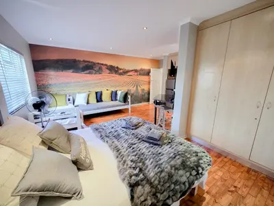 a bedroom with a bed with a painting on the wall at Royal Boland in Paarl