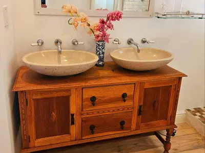 two sinks on a wooden stand with a vase with flowers at PinotageLuxuryCollection 9A Herte Suite in Stellenbosch