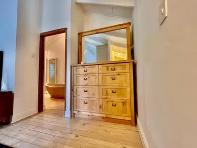 a bathroom with a dresser with a large mirror at PinotageLuxuryCollection 9A Herte Suite in Stellenbosch