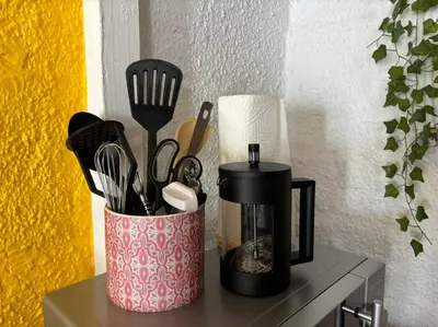 a container filled with utensils sitting on a counter at Mountain Views, beach walks, heart of old village in Gordonʼs Bay