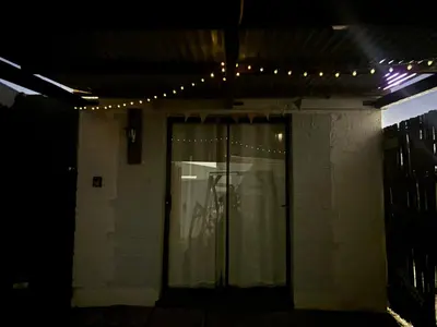 a building with a glass door with lights on it at Mountain Views, beach walks, heart of old village in Gordonʼs Bay