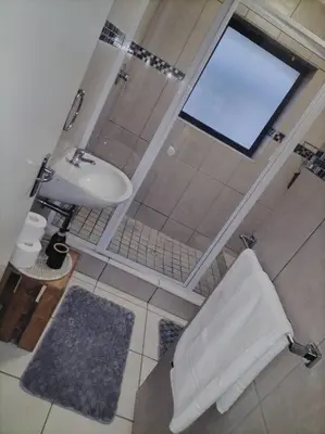 a bathroom with a toilet and a sink at Holihome in Brackenfell