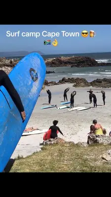 a group of surfers on the beach with their surfboards at Awesome room in surf house in Hermanus