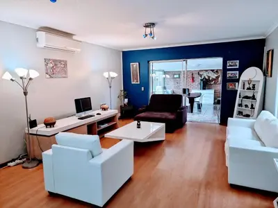 a living room with white furniture and blue walls at 3 bedroom garden house in Tableview in Table View