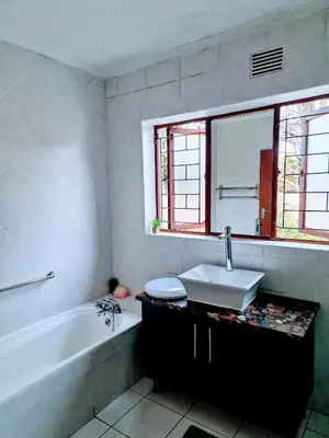 a bathroom with a tub and a sink and a bath tub at 3 bedroom garden house in Tableview in Table View