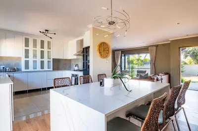 a kitchen and dining room with a large white island at 59onLetchworth in Cape Town