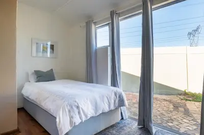 a bedroom with a bed and a large window at 59onLetchworth in Cape Town
