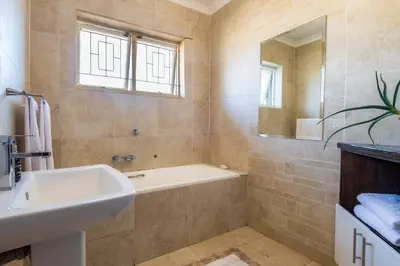 a bathroom with a sink and a tub and a mirror at 59onLetchworth in Cape Town