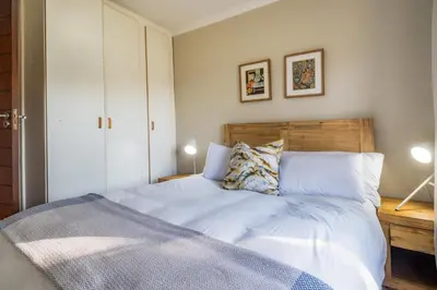 a bedroom with a bed with white sheets and pillows at 59onLetchworth in Cape Town